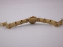 View showing the folded gold tone bracelet and its signed folding clasp.