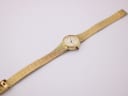 Full top-down view of the Rotary watch with the gold-tone mesh bracelet extended on a white background.