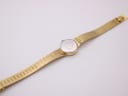 Full view of the Rotary watch from the back, showing the case back and the extended gold-tone mesh bracelet.