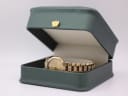 The Christian Dior watch nestled in a generic green presentation box with a gold crown emblem.