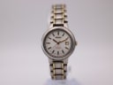 Straight-on view of the Seiko 7N82-0420 titanium two-tone watch with white dial and integrated bracelet on a neutral background.