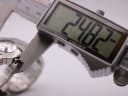 Digital caliper measuring the watch case, displaying a precise diameter of 24.82mm.