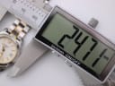 Digital caliper measuring the case diameter of the Tissot PR 50, displaying a precise measurement of 24.7mm.