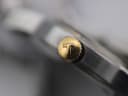 Macro close-up of the gold-plated crown of the Tissot PR 50, featuring the distinctive 'T' logo.