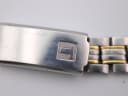 Close-up of the Tissot PR 50's stainless steel deployant clasp, showing the etched Tissot logo and visible surface scratches.