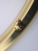 Macro shot of the fluted crown with the embossed Maurice Lacroix "M" logo.