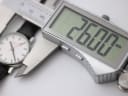 Digital caliper measuring the watch case, displaying a precise diameter of 26.00mm.