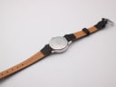 View of the watch from the back, showing the case back engraving and the inside of the black leather strap with "Anti-Allergy Leather 12" marked.