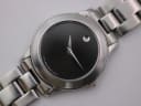 Close-up front view of the Movado black dial, showing the iconic single dot, silver hands, and "Swiss Movado Quartz" text.