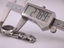 Digital caliper measuring the case diameter of the Movado watch, showing a precise reading of 27.89mm.