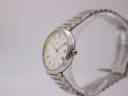 Angled side view of the Tissot Seastar watch on a clear stand, highlighting the gold-tone crown and case profile.