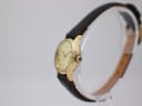 Side view of the gold-tone Zenith watch showing the crown and case profile.