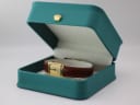 Raymond Weil 5744 watch displayed open in a green leatherette presentation box with a gold crown emblem.
