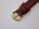Close-up of the gold-toned buckle on the brown leather strap, featuring the engraved "RW" logo.