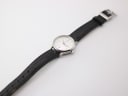 Overhead view of the XEN watch with its black leather strap laid flat.