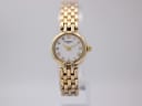 Front view of Raymond Weil 5892 ladies watch with gold-tone case and bracelet on a clear stand.