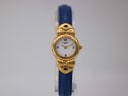 Front view of the Fontenay W 1303 watch, showcasing its gold-tone case, white dial with Arabic numerals, and blue textured leather bangle strap on a clear stand.