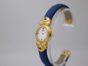 Angled view of the Fontenay W 1303 watch, highlighting the elegant curve of the blue leather bangle strap and the decorative gold-tone elements connecting the case.