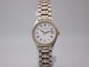 Front view of the Certina ladies' two-tone quartz watch with white dial and Roman numerals on a grey background.