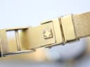 Close-up of the integrated gold-tone bracelet clasp with a textured finish and a squared Zenith logo.