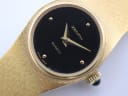 Close-up of the black Zenith quartz dial with gold hands, subtle baton markers, and "SWISS MADE" text at 6 o'clock.