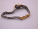 Rear view of the gold-tone integrated metal link bracelet, showing the design and fold-over clasp.