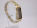 Left-side view of the vintage gold-plated Seiko watch on a stand, showing some case surface wear.