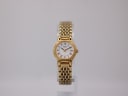 Front view of the gold-tone Seiko ladies' quartz watch with white Roman numeral dial on a clear display stand.