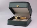 The gold tone Seiko watch resting inside a generic green presentation box.