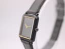 Angled side view of the Seiko watch, showing the black coated case, crown, and strap texture.