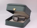 The Seiko watch displayed inside a generic green leatherette presentation box with a gold crown emblem.