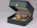 The gold Seiko watch displayed in a generic green leatherette presentation box with a gold crown emblem.