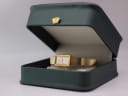 Seiko quartz watch displayed open in a dark green leatherette presentation box with a gold crown emblem.