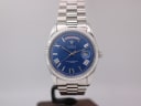 Front view of Cadisen C-8185G watch with blue dial, silver Roman numerals, day-date complication, and fluted bezel on a steel jubilee bracelet.