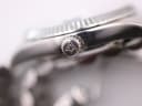 Extreme close-up of the crown of the Cadisen watch, showing the signed logo emblem.