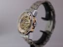 Side view of the Winner watch showing the crown and the gold-tone inner bezel, on a display stand.