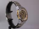 Other side view of the Winner watch showing the gold-tone inner bezel, on a display stand.