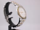 Angled side view of the Tissot Ballade watch, showing the brushed stainless steel and gold-plated links of the bracelet.