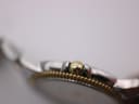 Close-up of the gold-plated crown and fluted bezel of the Tissot Ballade watch.
