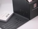 Close-up view of the interior of the original Tissot watch box, showing signs of wear and tear, with papers visible.