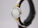 Angled side view of the Michel Herbelin watch on a black display stand, highlighting the two-tone case and crown.
