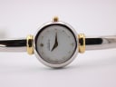 Overhead close-up view of the Michel Herbelin 17025 watch dial and the curved two-tone bangle bracelet.