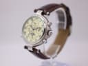 Angled side view of Stauer watch on display stand, showing case profile, crown and pushers.