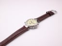 Top-down angled view of the watch, showing the full length of the brown leather strap with crocodile pattern.