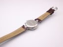 View from the back, showing the case back and the underside of the brown leather strap with 'Stauer' branding.