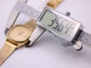 Digital caliper measuring the case diameter of the watch, displaying 35.64mm.
