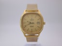 Front view of the gold-plated Tissot Seastar quartz watch with champagne dial and date window.
