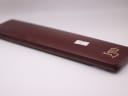 Top view of the closed burgundy presentation box, showing a small white sticker with a price "-1493" and a gold symbol.