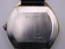 Close-up of the watch's brushed stainless steel case back, showing "BULOVA N7 BASE METAL BEZEL STAINLESS STEEL BACK" engraving.