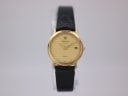Front view of gold PVD Raymond Weil 9920 quartz watch with textured gold dial, date, and black leather strap.